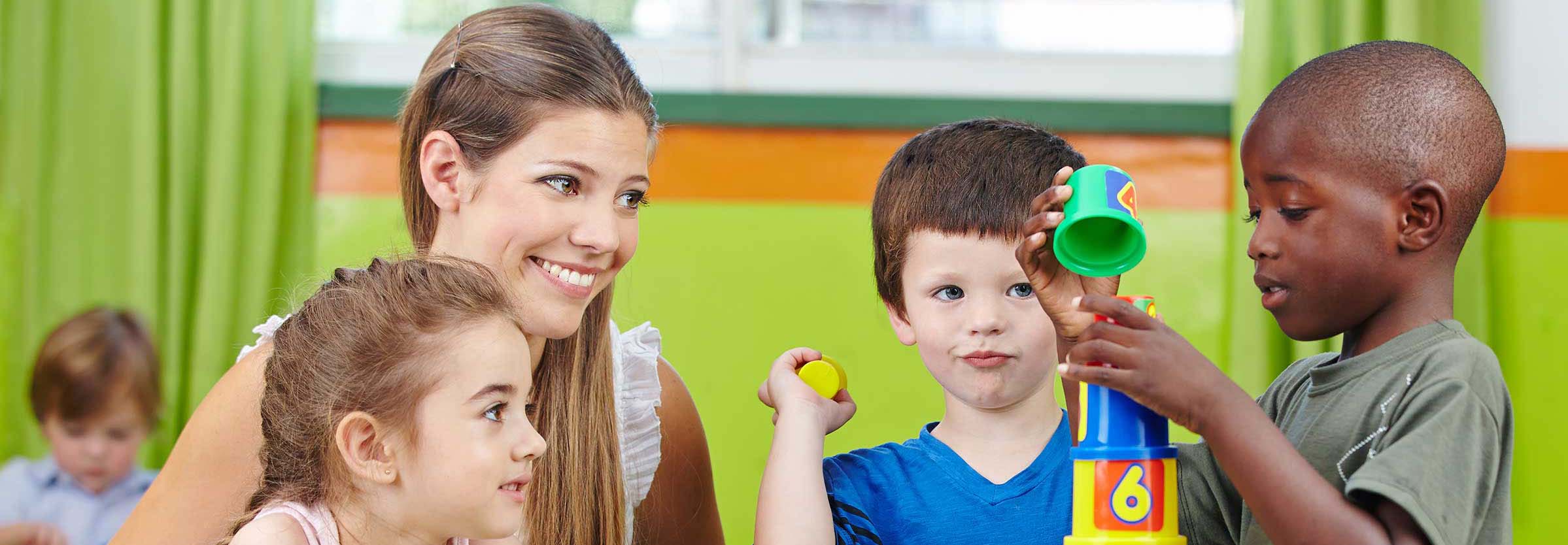 Teacher and children at a table working on a learning activity