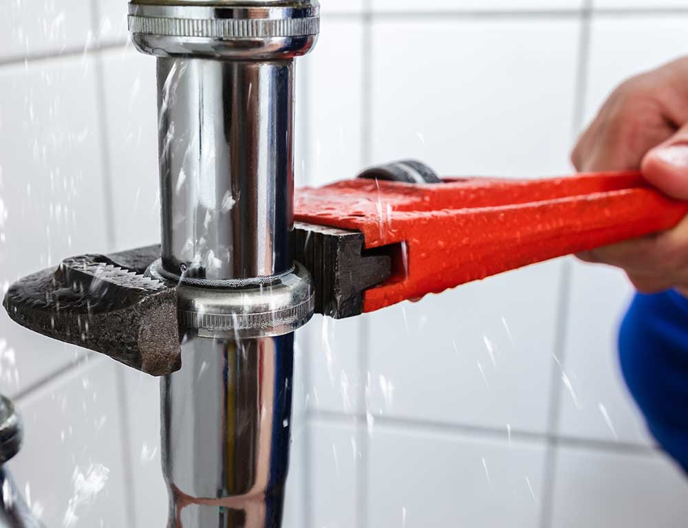 Plumber repairing a water pipe leak