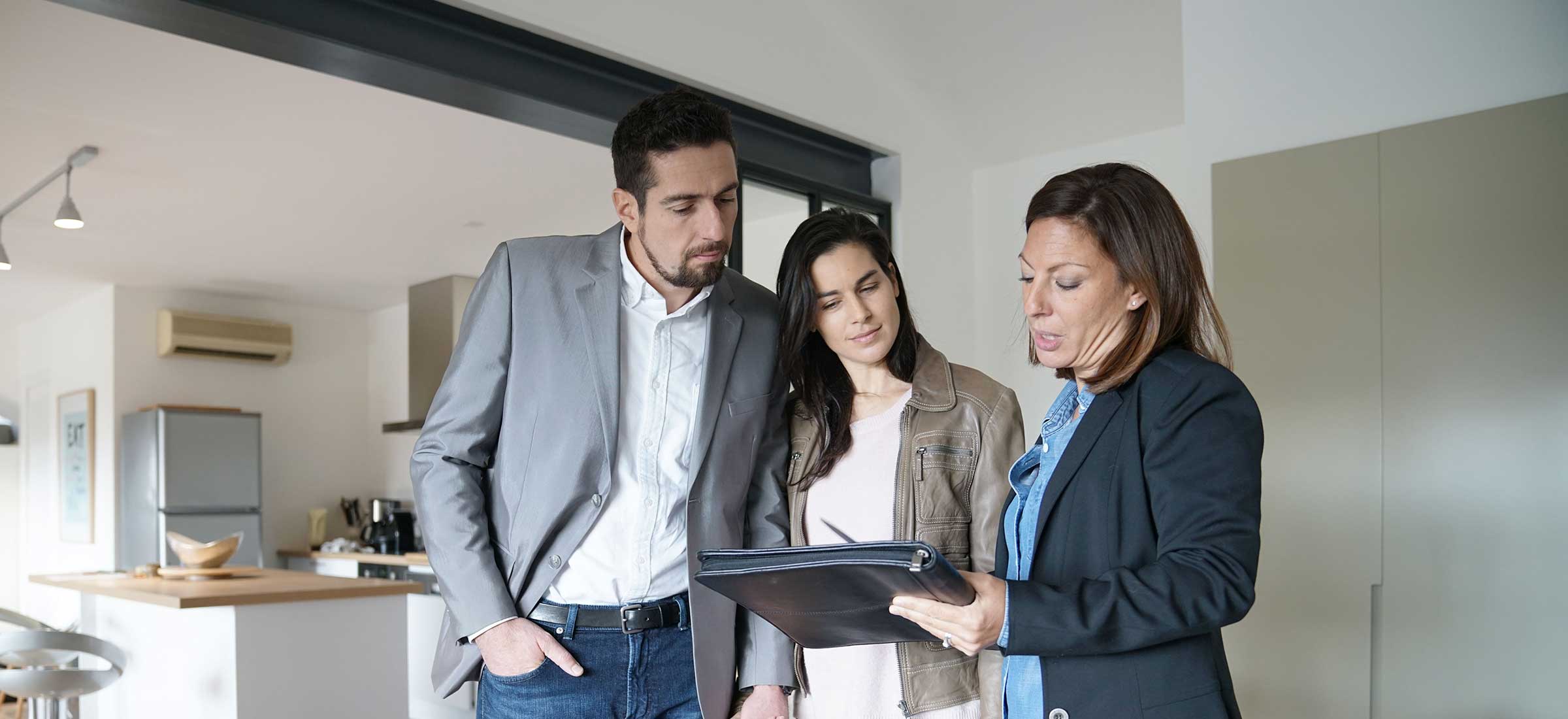 Couple with a real estate agent in a home for sale